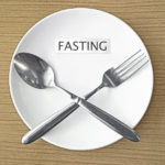 32697671 - fasting paper and fork with spoon symbol on white plate